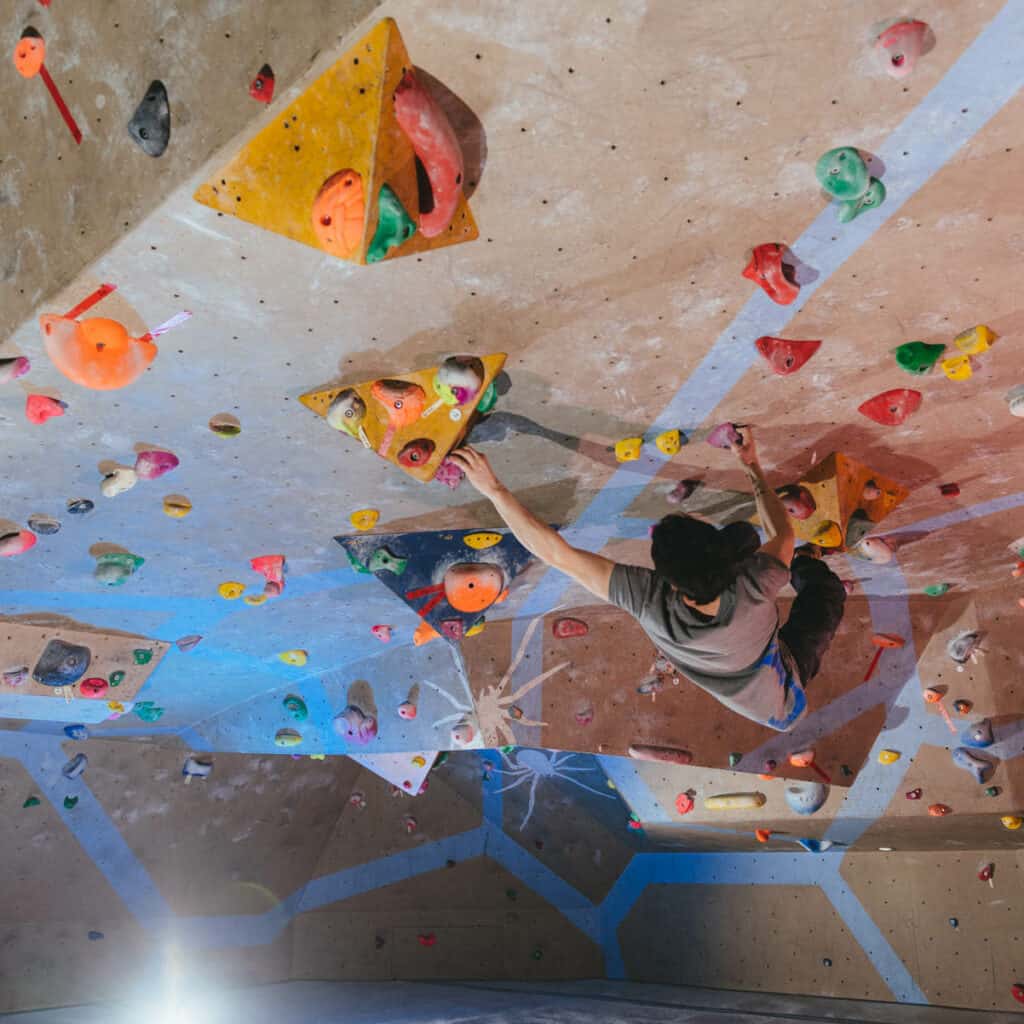 Child climbing up climbing wall