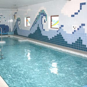 Therapy pool with a disco ball on the ceiling, mosaic waves on the wall and other sensory aspects.