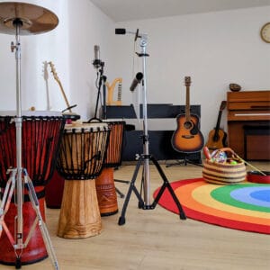 Music therapy studio with instruments including free standing drums, guitar and piano