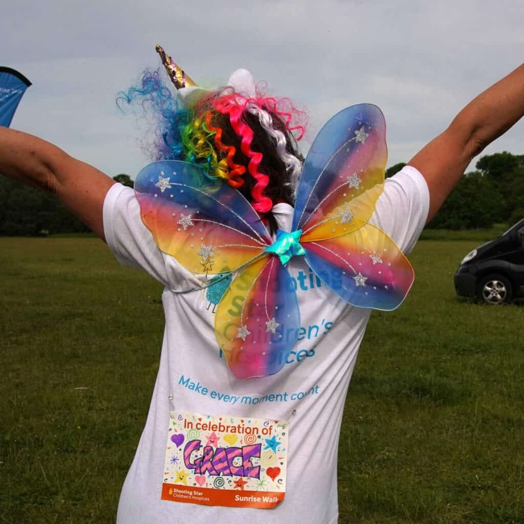 A supported family member with butterfly wings taking part in our sunrise walk