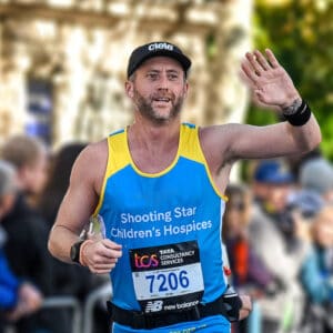 A man running in his Shooting Star branded blue and yellow running vest