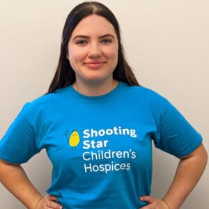 Woman wearing blue Shooting Star Children's Hospices t-shirt