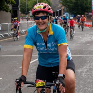 A cyclist wearing her blue and yellow cycling jersey.