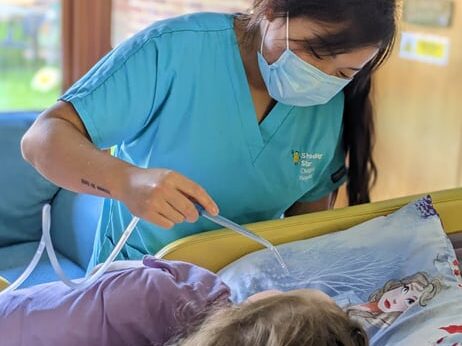 A nurse providing care to a child at the hospice