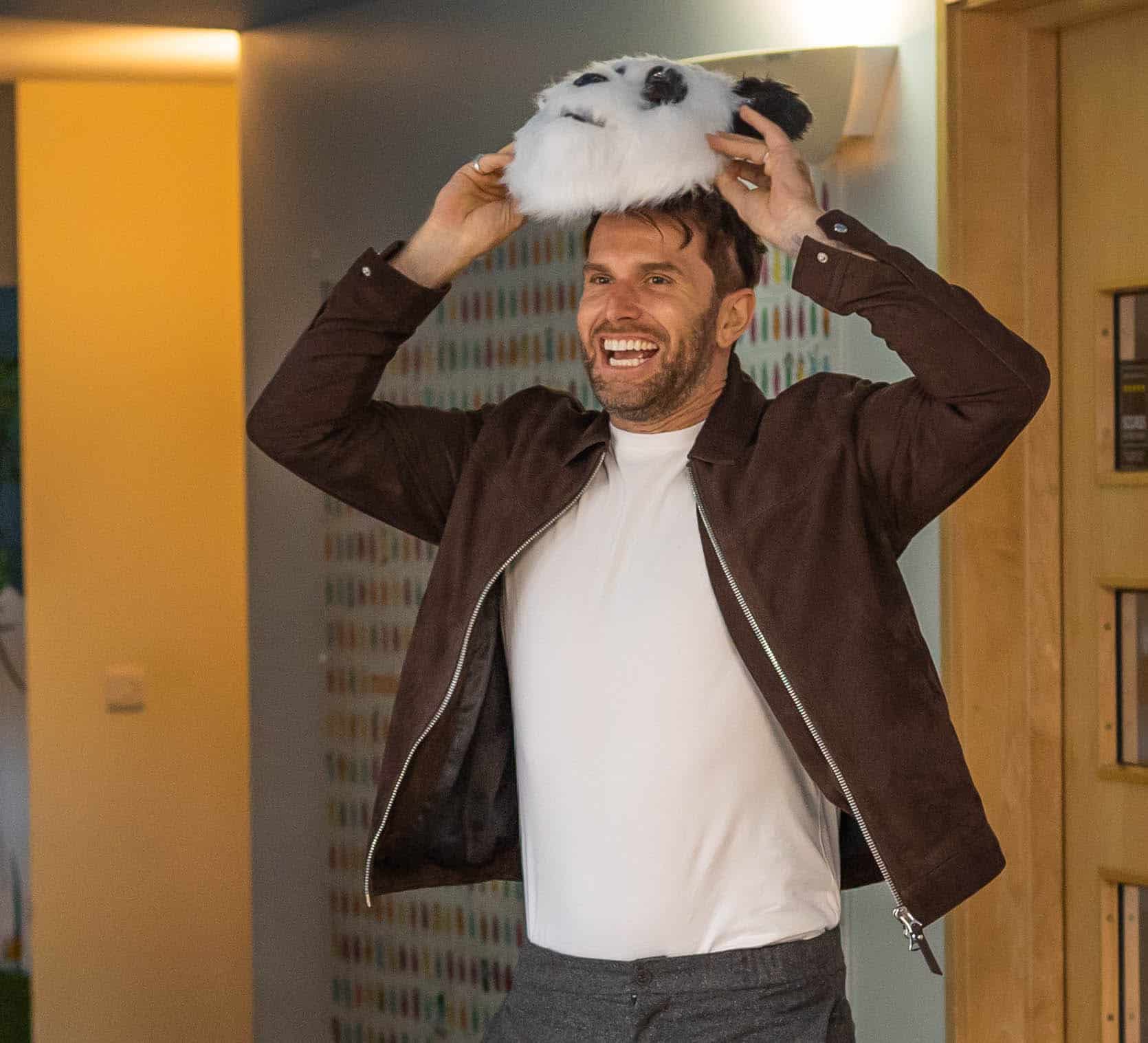 Joel Dommett lifting a Panda mask to reveal his face