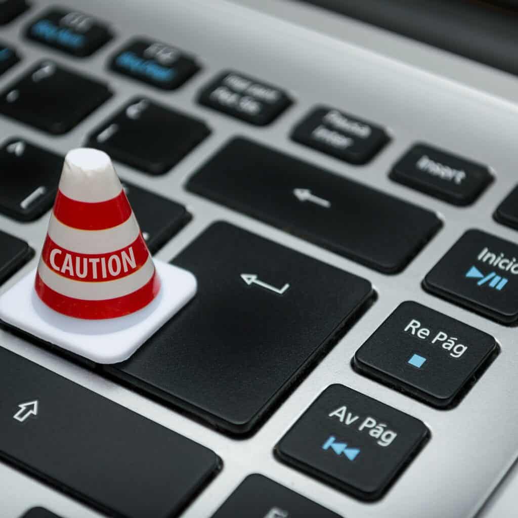 A tiny traffic cone on a keyboard, representing data security