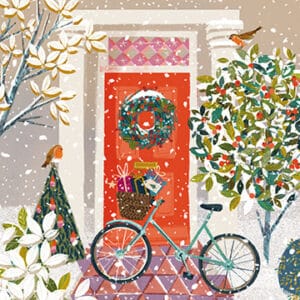 A bicycle propped against a red door at Christmas