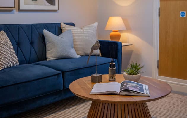 A blue couch and coffee table in a small room