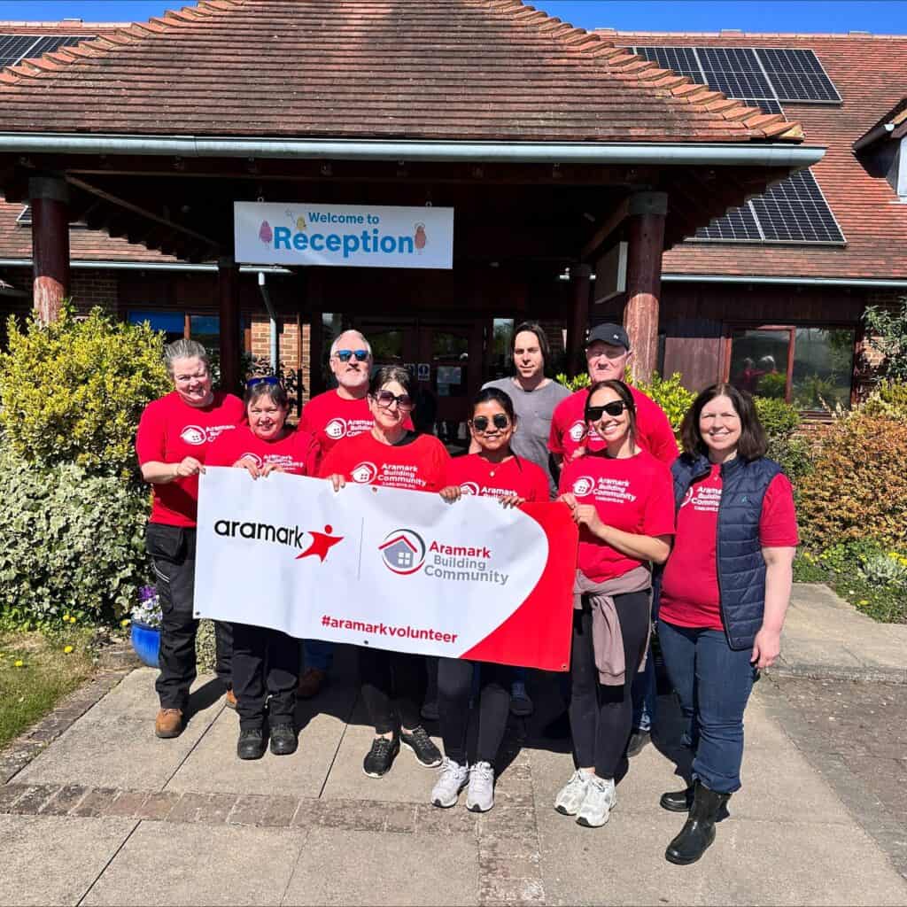 Group of volunteers holding a banner outside the hospice