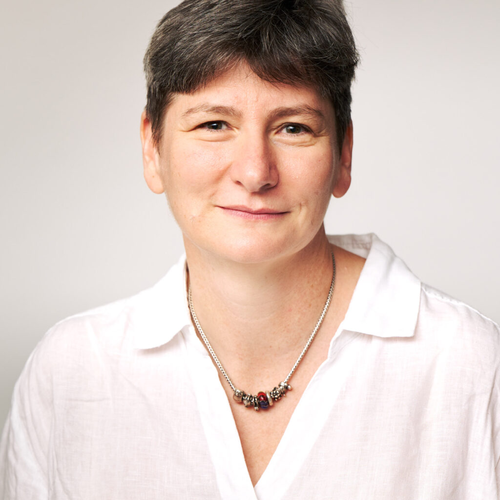 A woman in a white shirt and necklace