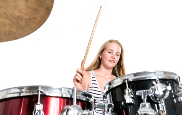 A teenager girl playing the drums