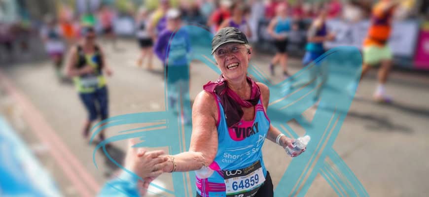 A female charity runner smiling and giving a high-five framed by a blue star on a blurred background.